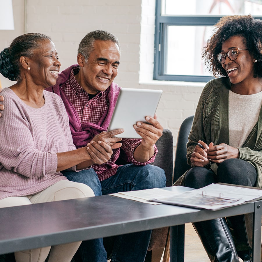 elderly Black couple consulting with a female Black gerontology worker