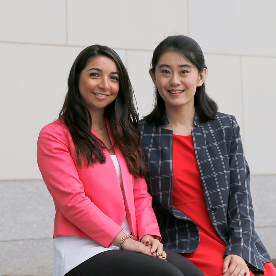 Two MBA students in front of university hall.