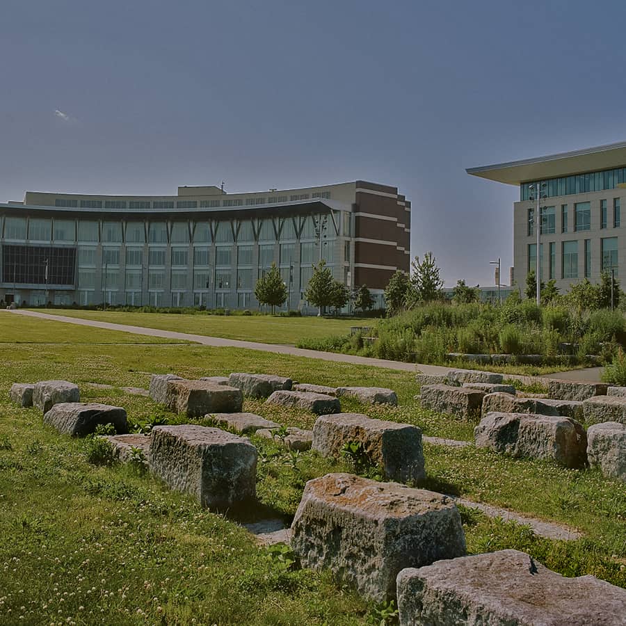 Campus Center with lawn and rough stone benches.