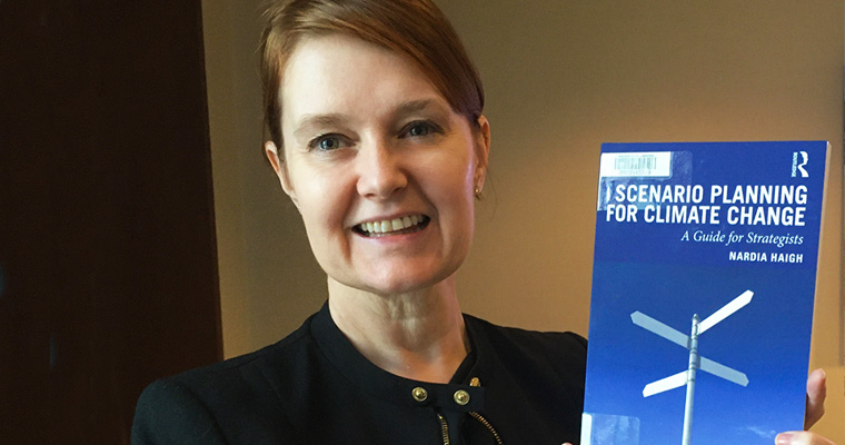 Professor Nardia Haigh holds up her book, Scenario Planning for Climate Change.