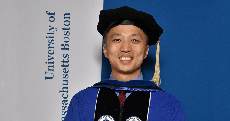 Xiaochuan Tong in cap and gown at graduation.