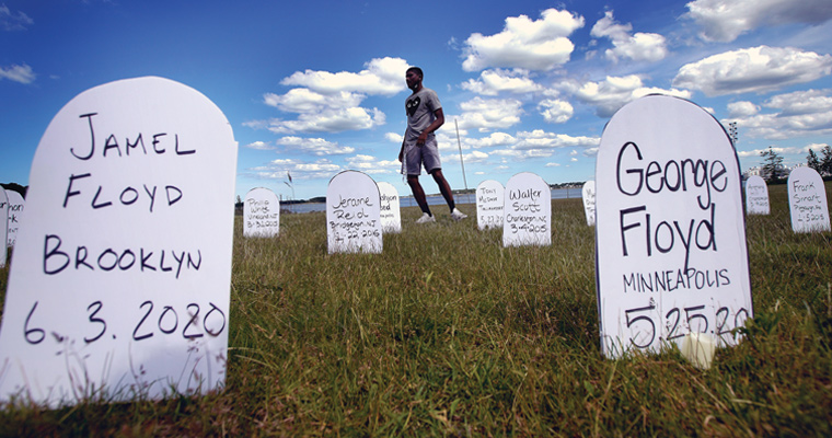 Abdullah Beckett ’21 installs names of 109 victims of racism and police brutality as part of a #saymyname art installation at UMass Boston