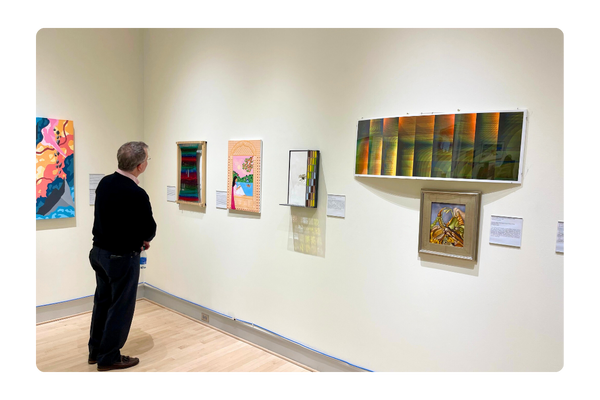 An alum views the artwork at the Alumni Art Exhibit Reception on Feb 29