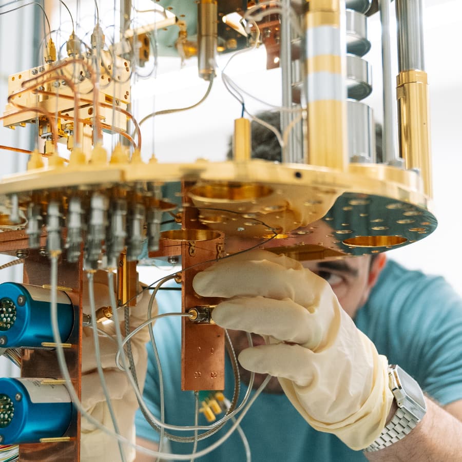 person adjusts quantum machine wearing gloves.